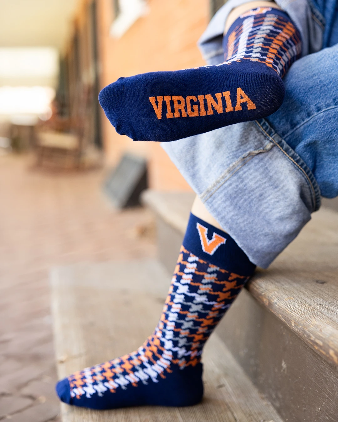 Person wearing socks reading "Virginia" sitting on steps.
